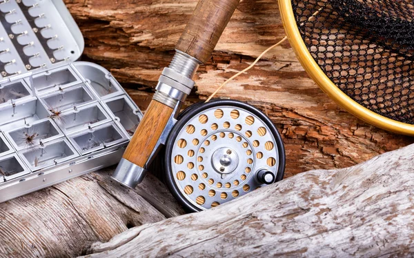 Roupa de pesca com mosca vintage e artes em rochas e fundo de madeira — Fotografia de Stock