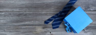 Mavi çizgili kravat ve yıpranmış tahta üzerinde hediye kutusu Mutlu Babalar Günü konsepti için. 