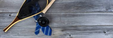 Mavi çizgili kravat ve yıpranmış ahşap tahtalar üzerinde uçan balık avı malzemeleri Mutlu Babalar Günü konsepti için. 