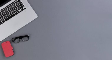 Masaüstü üzerinde akıllı telefon ve iş ya da okul konsepti için okuma gözlüğü olan mobil kablosuz dizüstü bilgisayar   