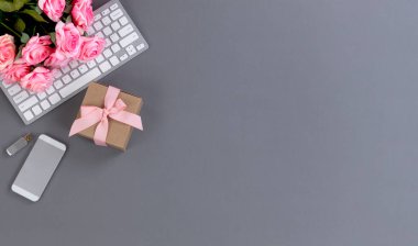 Bilgisayar klavyesi, hediye kutusu, akıllı telefon ve güzel pembe gül çiçekleriyle dolu masaüstü çalışma alanı, Anneler Günü tatili konsepti için bolca fotokopi alanı bulunuyordu. 