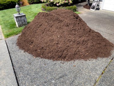 Pile of fresh topsoil dirt in home driveway for lawn maintenance clipart