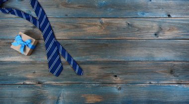 Mutlu babalar günü konsepti için soluk mavi tahta üzerinde boyun kravatı ve hediye kutusu. 