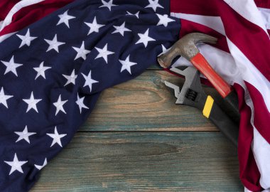 Amerikan bayrağı ve soluk mavi ahşap üzerine inşaat araçlarıyla Mutlu İşçi Bayramı konsepti 