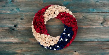 Wreath with United Stages national colors of red, white and blue with stars on faded blue wooden planks for happy memorial or Independence Day background concept  clipart