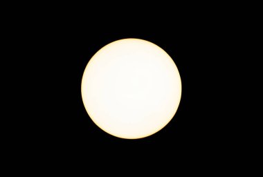 LED soft warm light bulb lit isolated on black background from overhead view. Yellow color to the lighting at 2700 Kelvin degrees. 