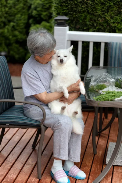 Mujer Mayor Sosteniendo Perro Mascota Mientras Prepara Hierbas Afuera Cubierta — Foto de Stock