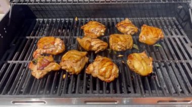Tavuk eti ızgarada pişiriliyor, dumanla birlikte.