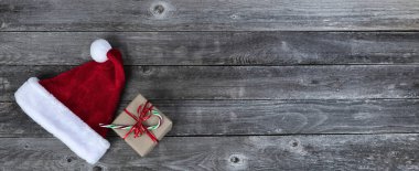 Kırmızı Noel Baba şapkası ve hediye kutusu artı soluk tahta üzerinde şeker kamışı Mutlu Noeller ya da mutlu yeni yıl kutlamaları 
