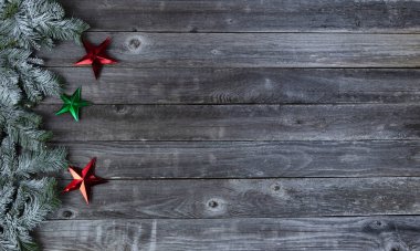 Mutlu bir Noel ya da yeni yıl kutlaması konsepti için solmuş ahşap kalasların üzerinde yıldızlarla kaplı donmuş kar dalları. 