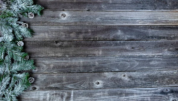 霜雪覆盖着常绿的枝条 松果装饰在褪了色的木板上 以庆祝圣诞节或新年佳节 — 图库照片