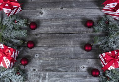 Her köşede hediye kutusu artı köknar dalları ve soluk tahta üzerinde kırmızı top süslemeleri Mutlu Noeller ya da mutlu noeller kutlaması konsepti 