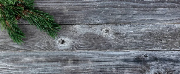 Real Fir tree branches on rustic wooden plank background for a merry Christmas or happy New Year holiday celebration concept