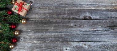 Gerçek köknar ağacı dalları, hediye kutusu, altın ve kırmızı top süsleri kırsal ahşap arka planda Mutlu Noeller ya da mutlu noeller bayramı kutlaması konsepti için  