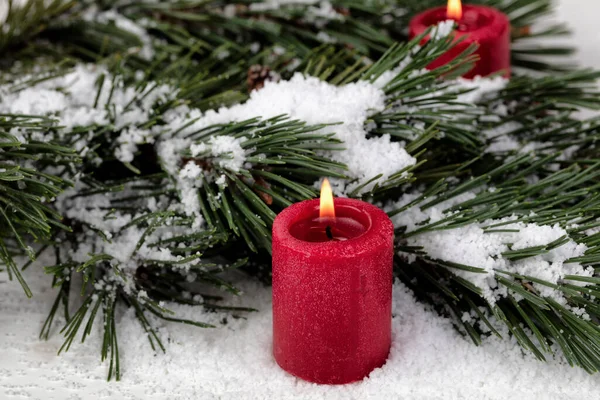 Close Uitzicht Een Gloeiende Rode Kaars Met Besneeuwde Dennenbomen Takken — Stockfoto