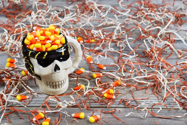 Close-up van enge halloween skeleton schedel cup gevuld met snoep — Stockfoto