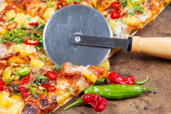 Gourmet pizza being cut into slices — Stock Photo, Image