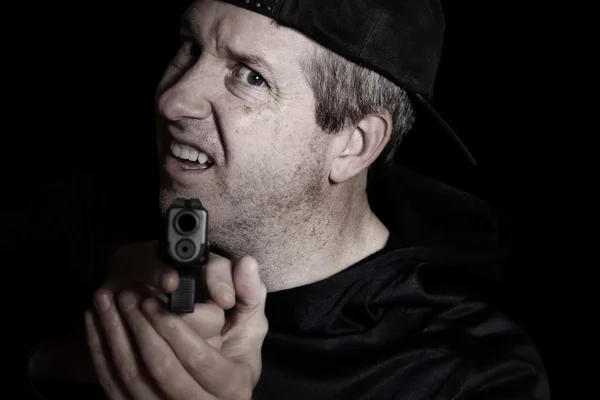 Человек показывает гнев с оружием, указывающим вперед в темноте — стоковое фото