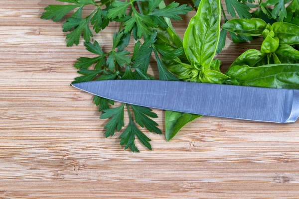 Hierbas frescas y cuchillo en la tabla de cortar —  Fotos de Stock