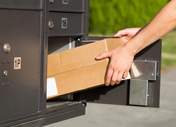 Oppakken van pakketten in de mailbox — Stockfoto