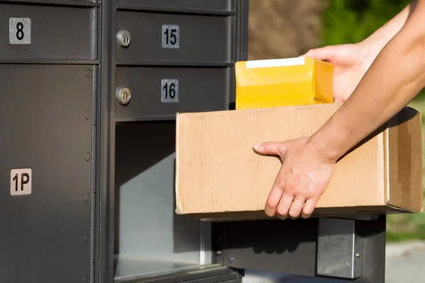 Packages being loaded into postal mailbox — Stock Photo, Image
