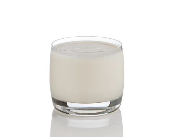 Bicchiere pieno di latte fresco su bianco con riflesso — Foto Stock
