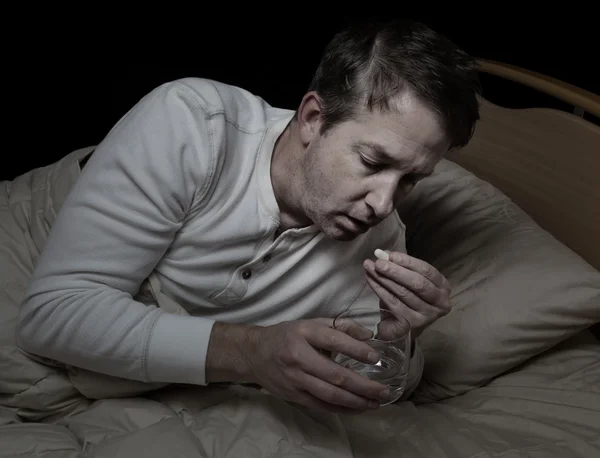 Homem doente tomando remédio com água — Fotografia de Stock