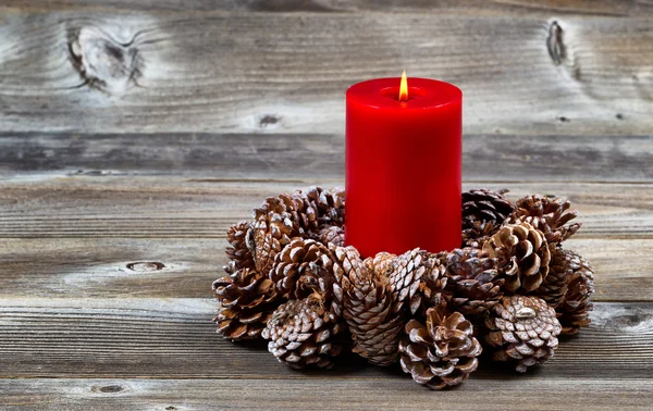 Vela roja ardiente y corona de cono de pino para la temporada de Navidad —  Fotos de Stock