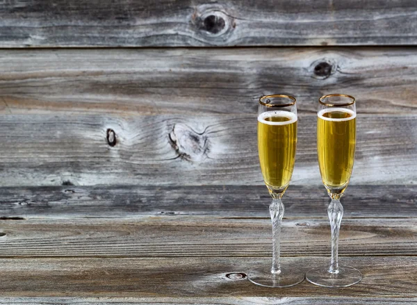 Golden Champagne in tall glasses on weathered wood — Stock Photo, Image