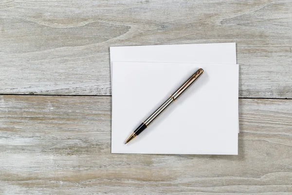 Trä-skrivbordet med vitt kuvert och penna — Stockfoto