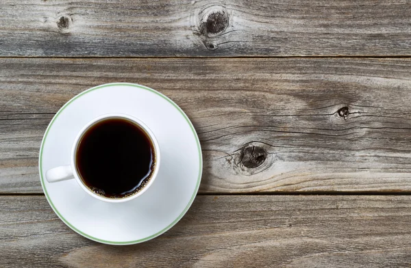 Frischer Kaffee in Tasse und Untertasse auf altem Holz — Stockfoto