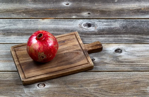 Reifer ganzer Granatapfel auf altem hölzernen Serverbrett — Stockfoto