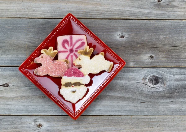 Weihnachtsplätzchen in rotem Teller auf Holz — Stockfoto
