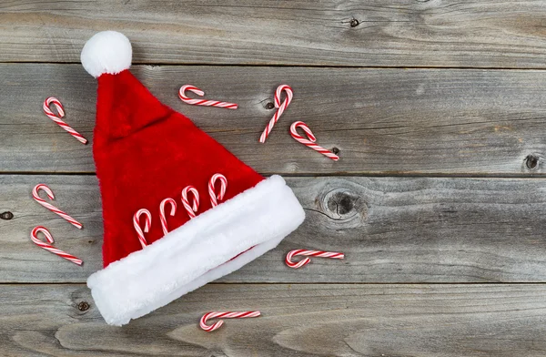 Santa Hat e Candy Canes em madeira rústica — Fotografia de Stock