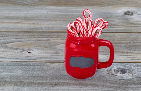 Taça vermelha cheia de bastões de doces para a temporada de férias — Fotografia de Stock