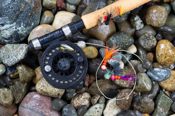 Fly Fishing Pole and Reel with Flies on Wet Stones Stock Image