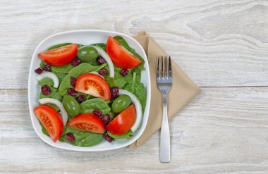 Çatal ve peçete beyaz tabakta taze salata