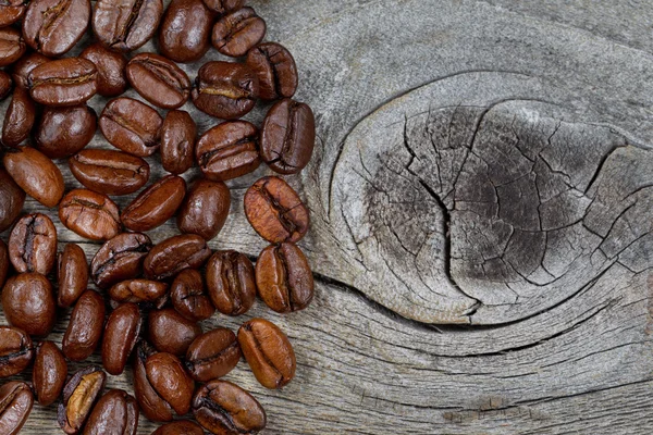 Granos de café tostados frescos en madera rústica — Foto de Stock