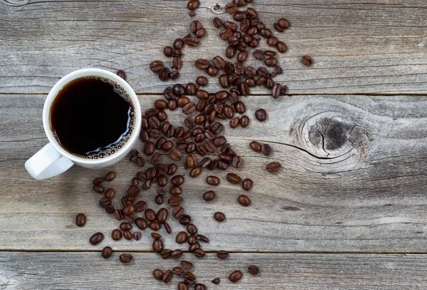 Dark Coffee and beans on rustic wood — Stock Photo, Image