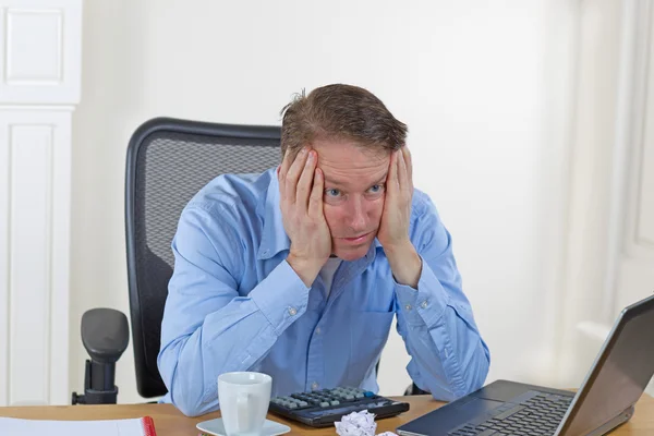 Älterer Mann sieht bei der Arbeit verloren aus — Stockfoto