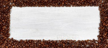 Beyaz ahşap üzerine taze kahve çekirdekleri 