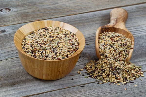 Raw Rice in wooden kitchenware spilling onto rustic wood — Stock Photo, Image