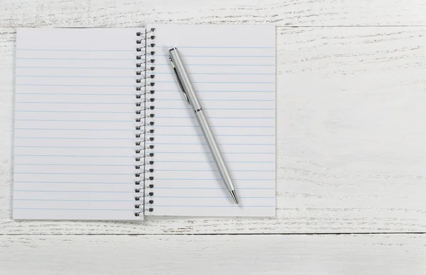 Weißer Schreibtisch mit Notizblock und Stift — Stockfoto