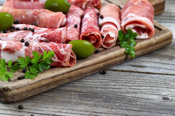 Varias carnes crudas en la tabla de servir con fondo rústico — Foto de Stock