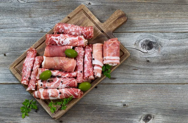 Various raw meats on rustic serving board — Stock Photo, Image