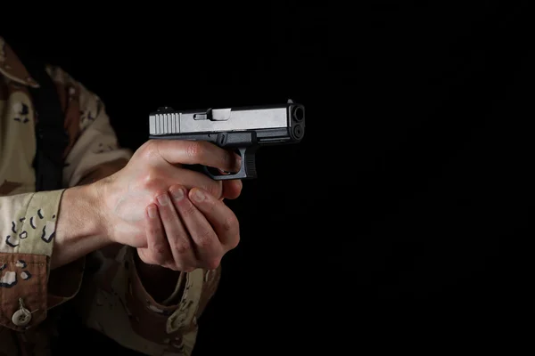 Soldado masculino apontando sua arma na escuridão — Fotografia de Stock