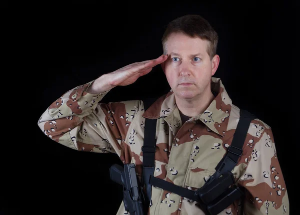 Hombre soldado dando saludo mientras está bajo los brazos — Foto de Stock