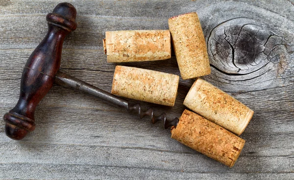 Vintage Corkscrew with used corks on aged wood — Stock Photo, Image