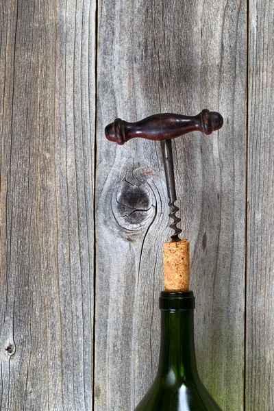 Vintage corkscrew ta bort kork från vinflaska med trä backg — Stockfoto