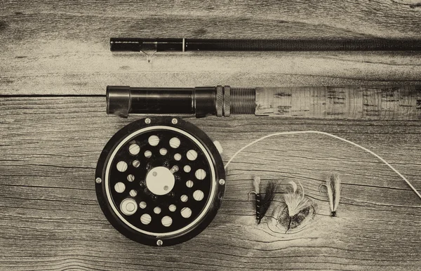 Vintage fly reel and rod on aged wood — Stock Photo, Image